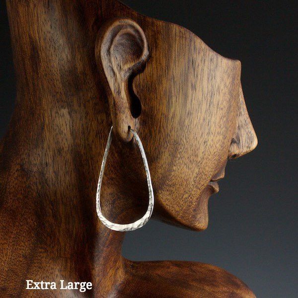 Extra large sterling silver elliptical hoop earrings on model
