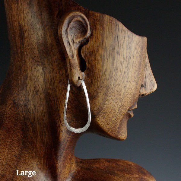 Large sterling silver elliptical hoop earrings on model