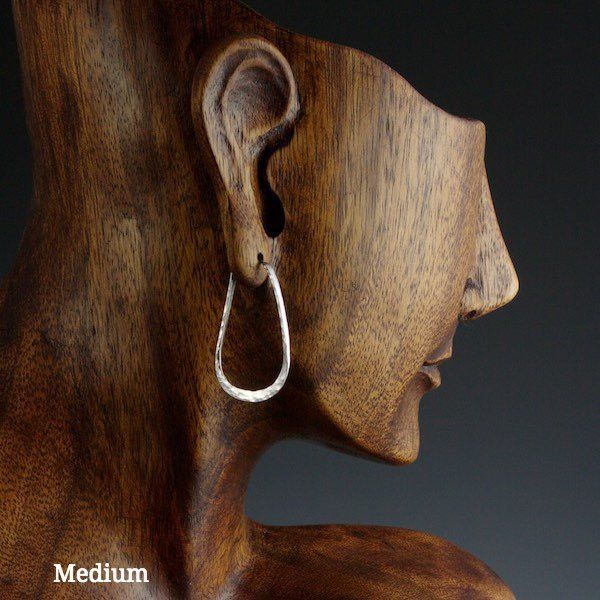Medium sterling silver elliptical hoop earrings on model